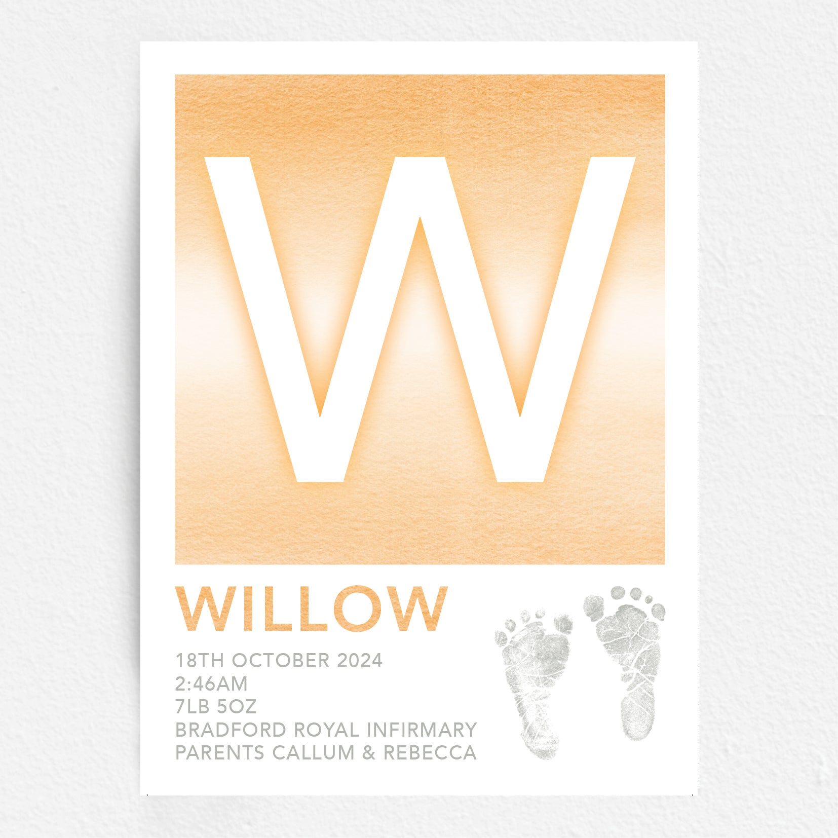A personalised baby print with the initial 'W' in large orange lettering, birth details, and baby feet prints.