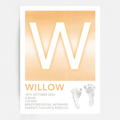 A personalised baby print with the initial 'W' in large orange lettering, birth details, and baby feet prints.