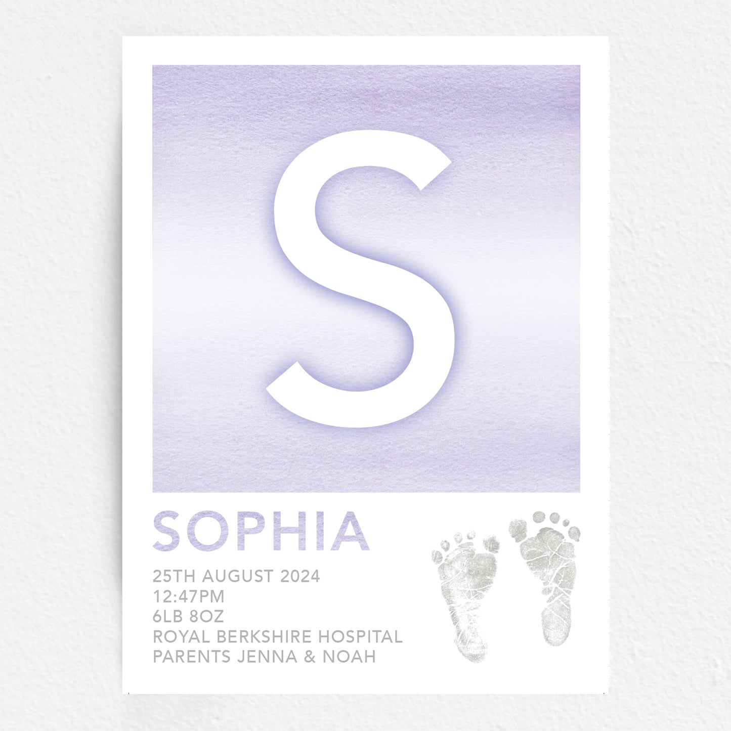 A personalised baby print with the initial 'S' in large purple lettering, birth details, and baby feet prints.