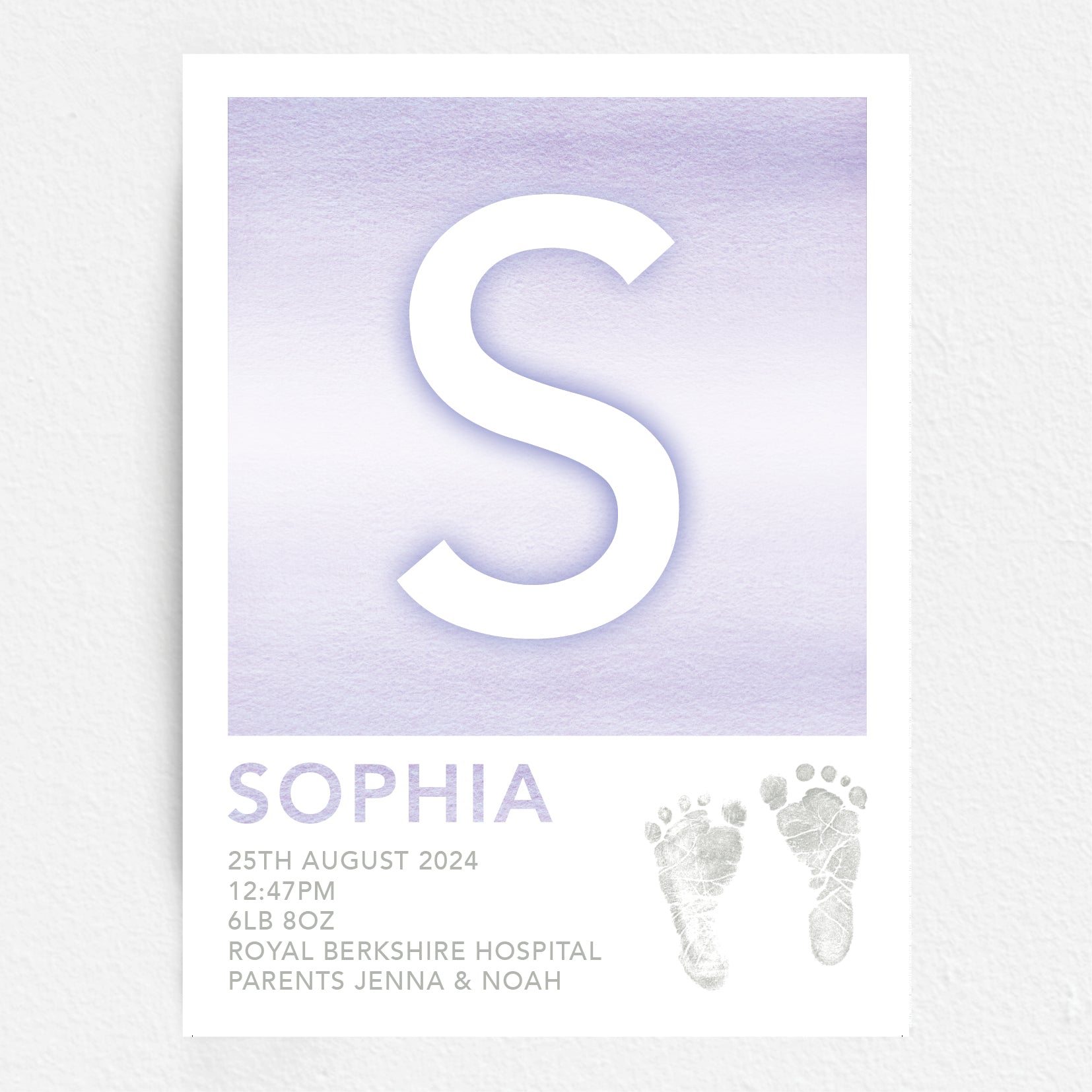 A personalised baby print with the initial 'S' in large purple lettering, birth details, and baby feet prints.