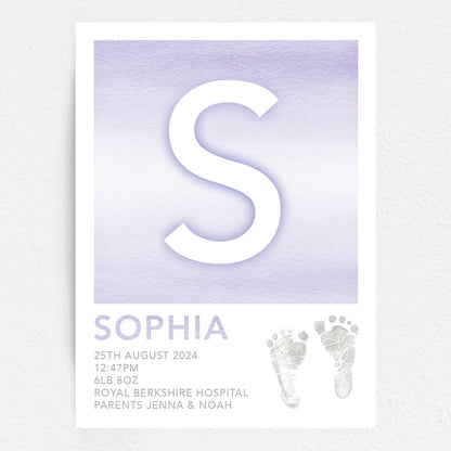 A personalised baby print with the initial 'S' in large purple lettering, birth details, and baby feet prints.
