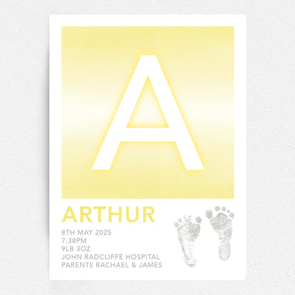 A personalised baby print with the initial 'A' in large yellow lettering, birth details, and baby feet prints.