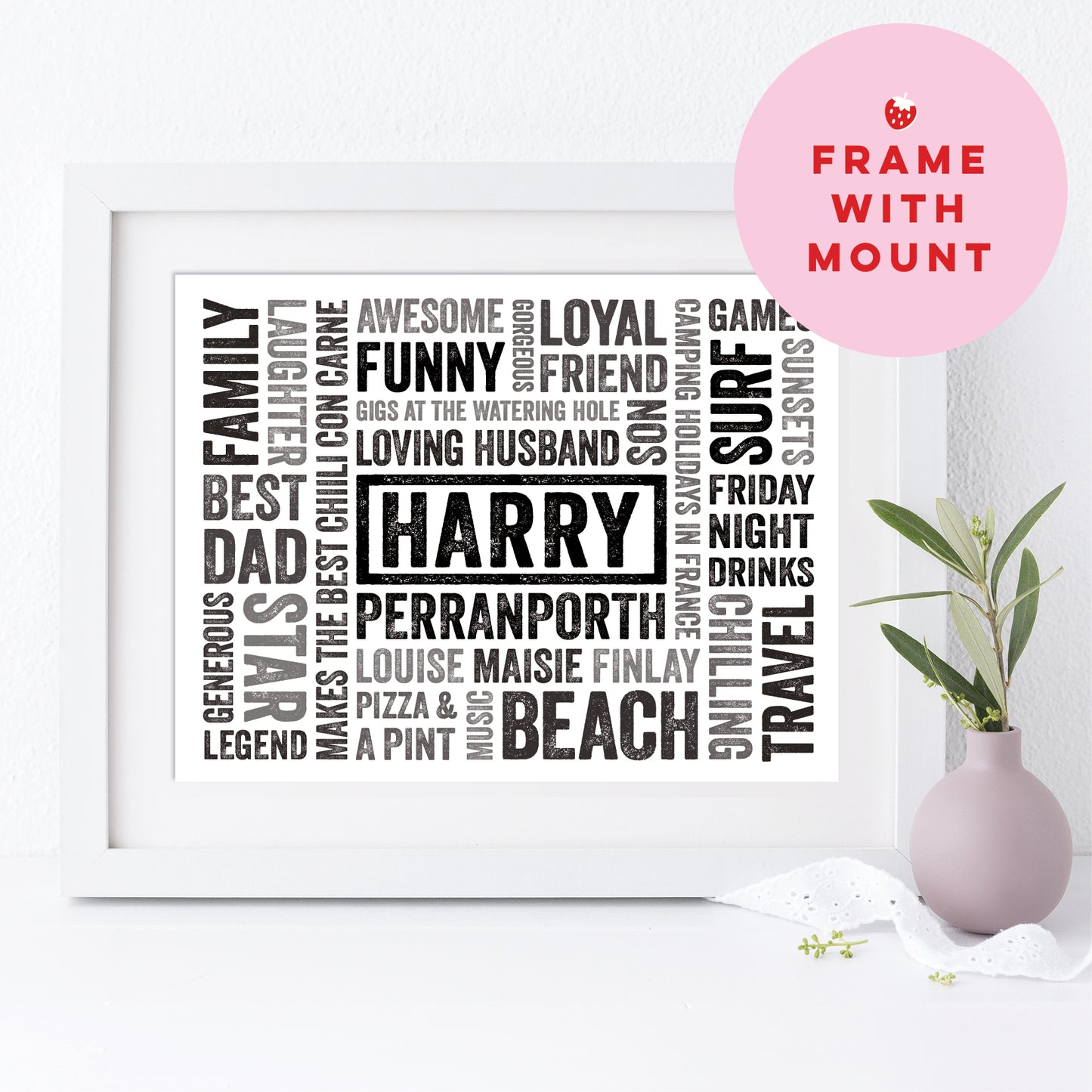 Framed print with personalized text on a white surface with a pink vase and plant.