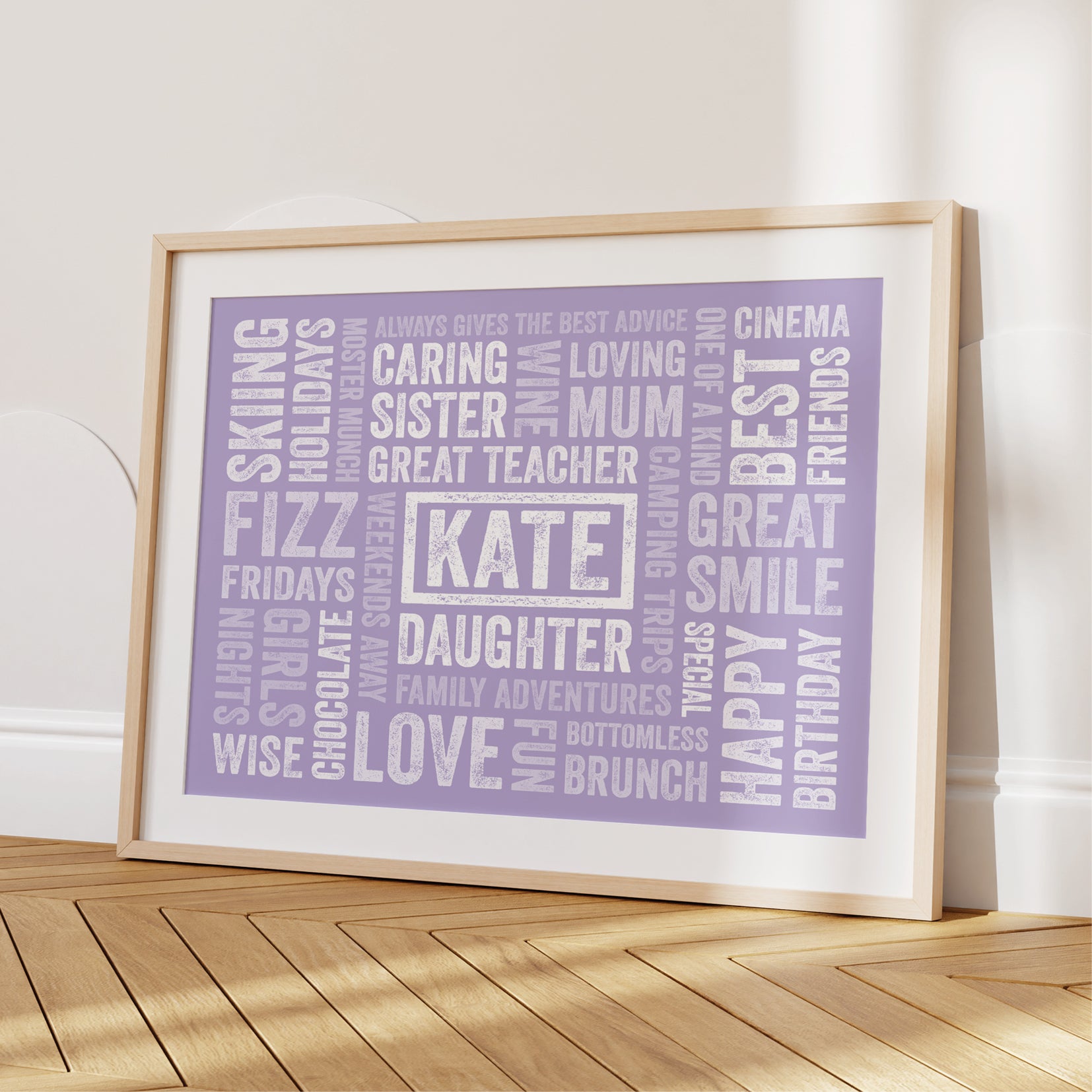 Framed purple word art print on a wooden floor against a white wall