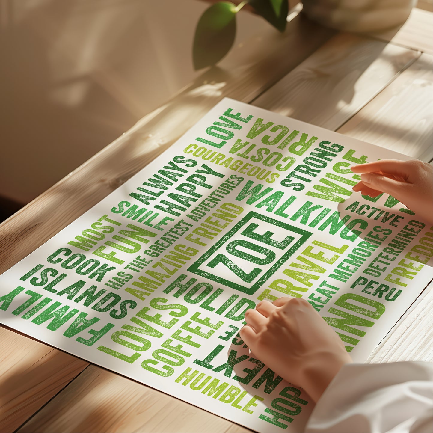 Sheet of green printed words on a wooden surface with a hand holding a piece of paper.