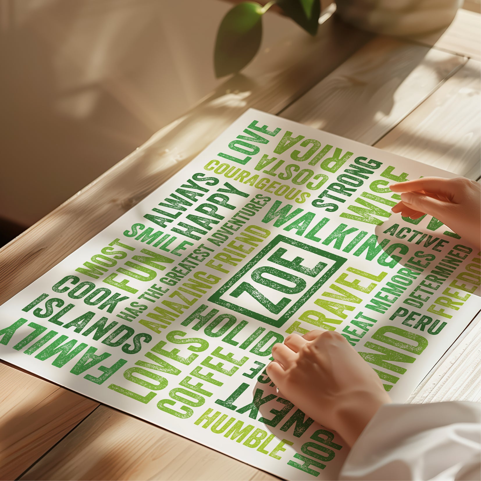 Sheet of green printed words on a wooden surface with a hand holding a piece of paper.
