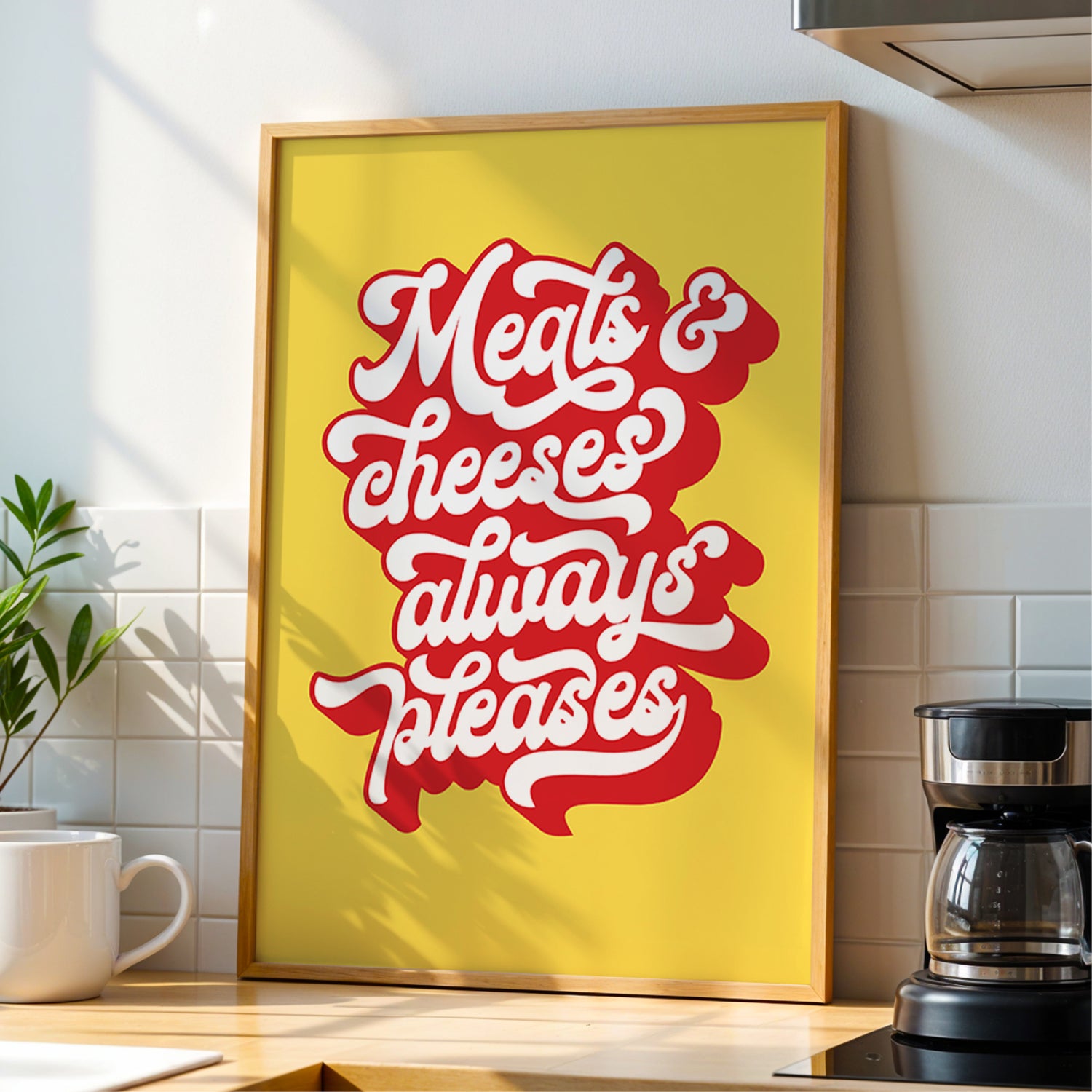 Framed poster with 'Meats & cheeses always please' text in a kitchen setting
