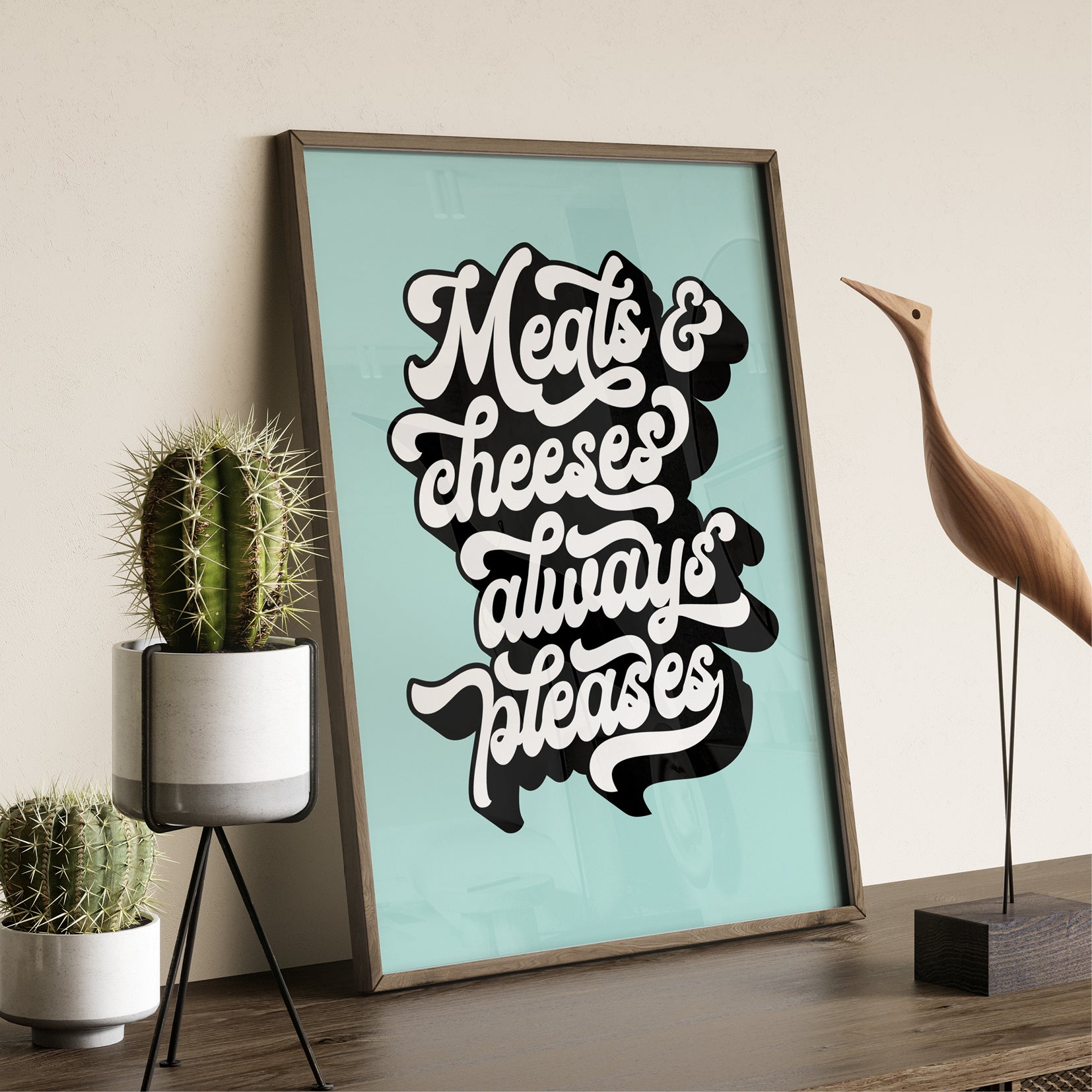 Art Print text 'Meats & cheeses always pleases' on a light blue background in a dark wood frame