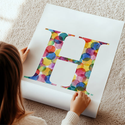 large allphabet initial letter 'H' made of colorful kaleidoscope circles on a white poster